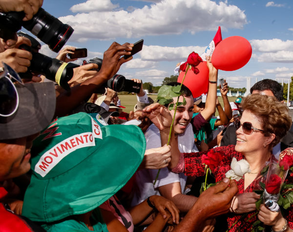 Ex-presidente Dilma Rousseff recebe flores de militantes ao deixar o Palácio da Alvorada (foto: Wilson Dias/Agência Brasil)